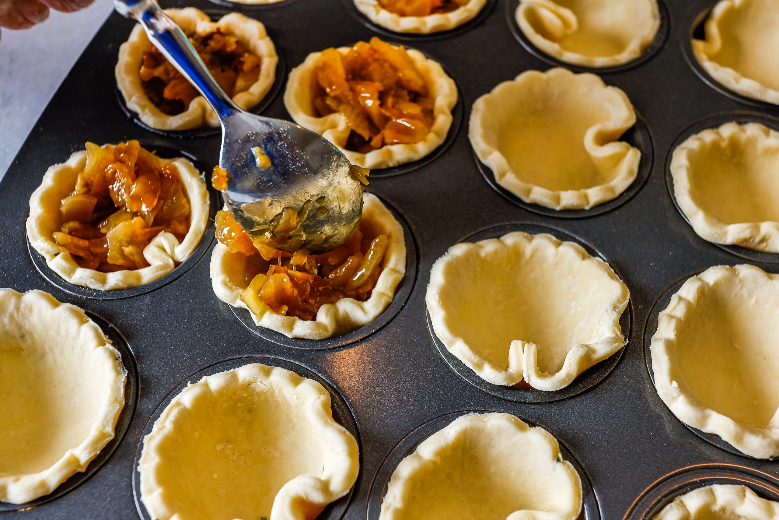 To prepare the Caramelized Onion Tartlets, combine the flour, thyme, and salt in a bowl and toss in the butter cubes to coat with flour. Working quickly, combine the mixture. After the pastry mixture has rested in the refrigerator, roll it out to ⅛-inch thickness. Using a cookie cutter, cut 3-inch circles of dough and tamp the rounds into mini muffin pans. Drop 2 to 3 teaspoons of the caramelized onion into each tart shell. Bake at 425 F for 18 to 20 minutes.