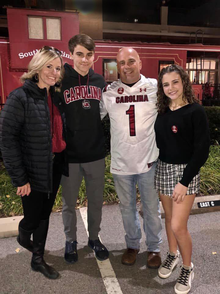 The Anderson family in front of a USC Cockaboose: Tish; Kaden; Billy, director of sports performance and baseball strength coach; and Ashlyn.