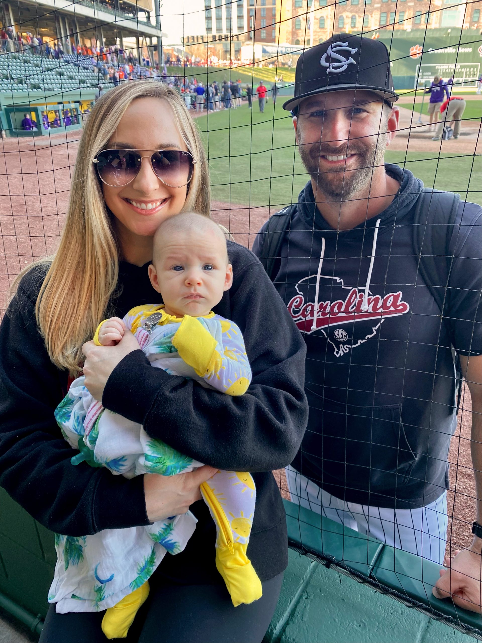 Angela and baby Cameron visit from the dugout with husband and father Justin Parker, who is in his second season as the Carolina pitching coach.