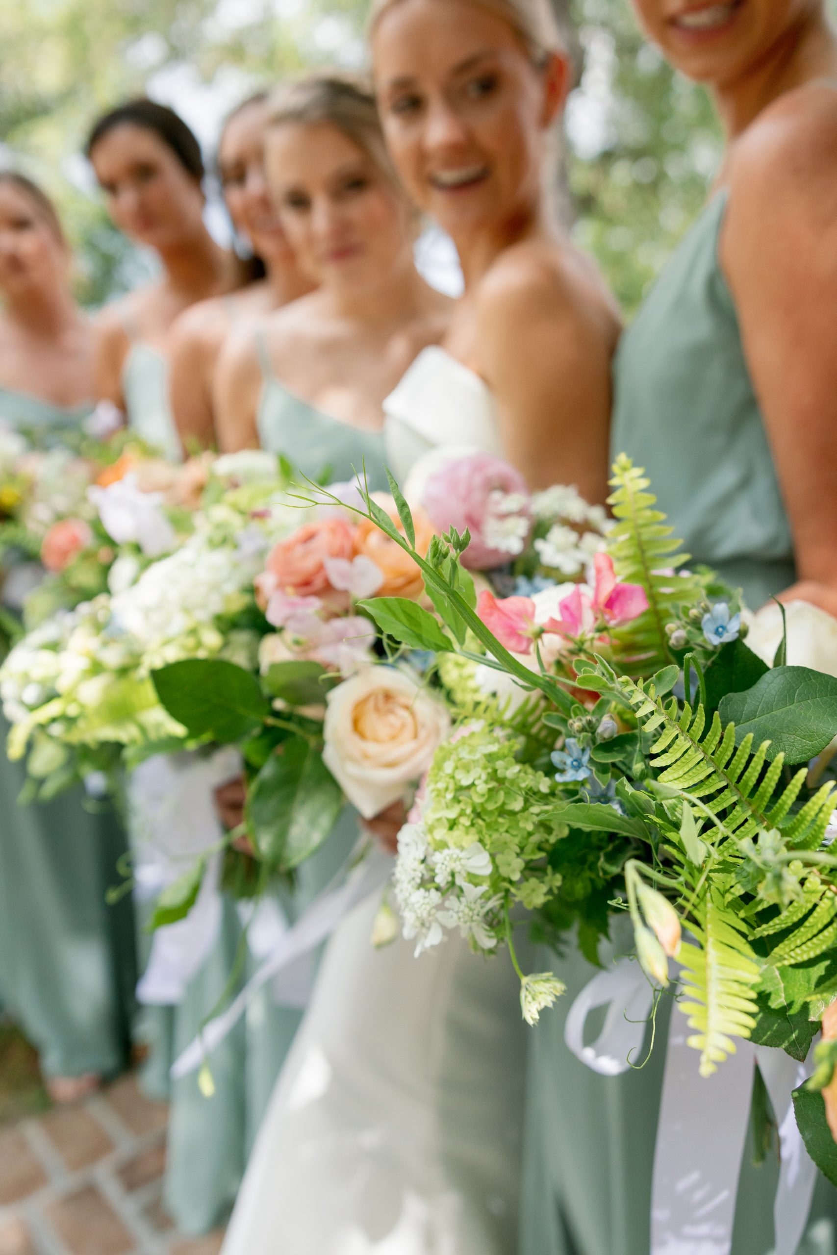 Blake’s bridesmaids, with makeup by POUT and hair by Process, wore identical dresses and carried spring flowers including hydrangeas, sweet pea, poppies, fern, and a soft fuzzy flower called tweedia. Dainty streamers on each bouquet added a whimsical touch. 