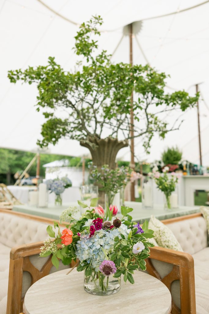 Blake knew she wanted the wedding vibe to be fun and locally sourced, which meant incorporating lots of native plants along with personal items from around the family farm. Wedding  planner Julianne Sojourner with My Friends Garden used majestic water oak branches to fill large urns on tables in the seating area under one of the tents. 