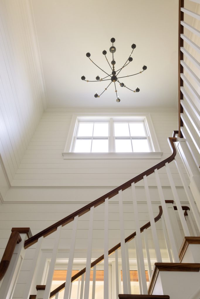 Details, like this porch ceiling fan and open stairwell, make the home personal and unique. Below: The expansive living room is the family’s favorite room in the house. 