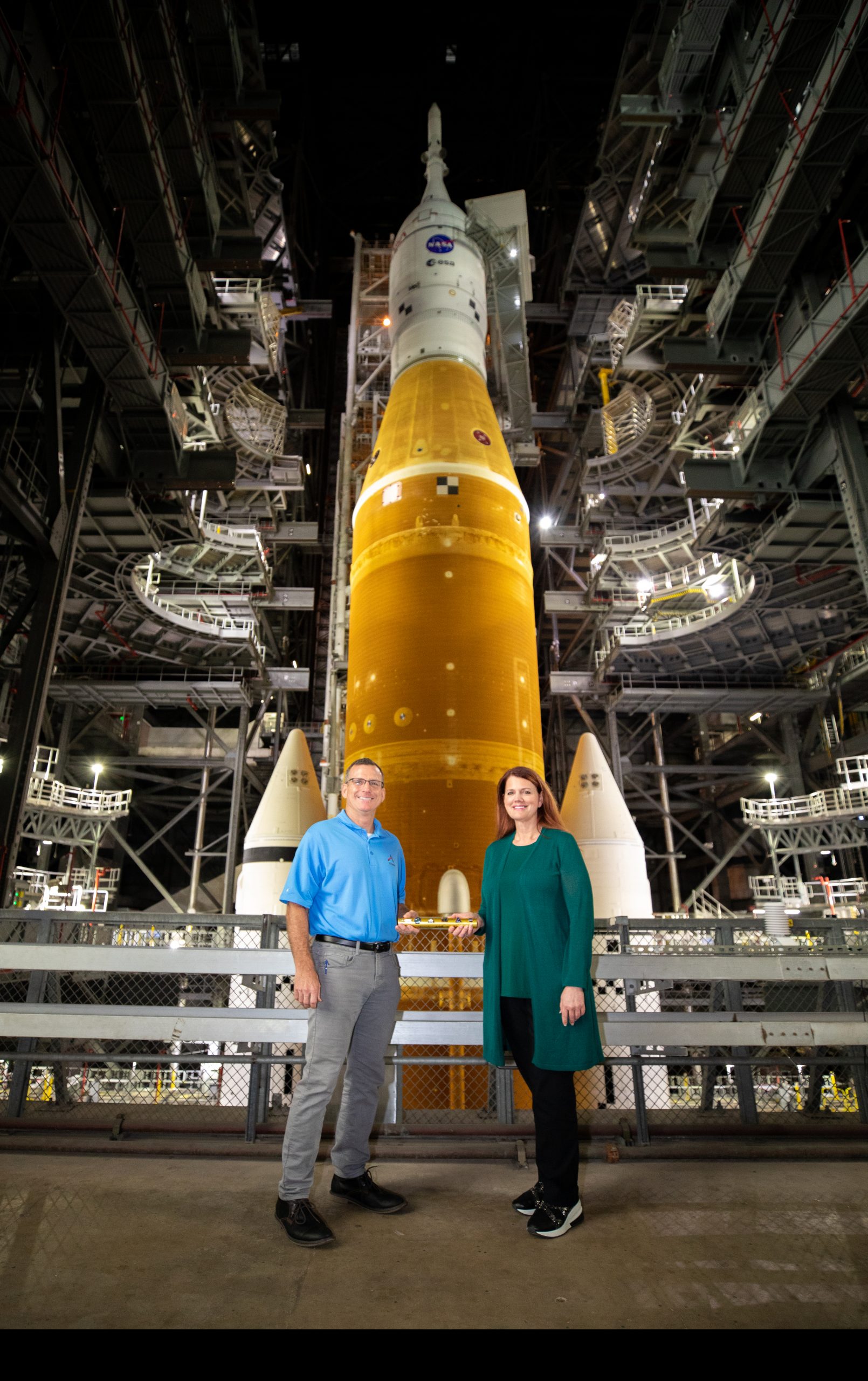 Ground operations manager Clif Lanham with Exploration Ground Systems passed the baton to Charlie Blackwell-Thompson, Artemis I launch director, inside the Vehicle Assembly Building at NASA’s Kennedy Space Center in Florida on March 16, 2022. Behind them is the Artemis I Space Launch System with the Orion spacecraft atop the mobile launcher. Charlie is a vital team member for the Artemis Mission, NASA’s first initiative to return humans to the moon in more than 50 years.  Photography courtesy of NASA