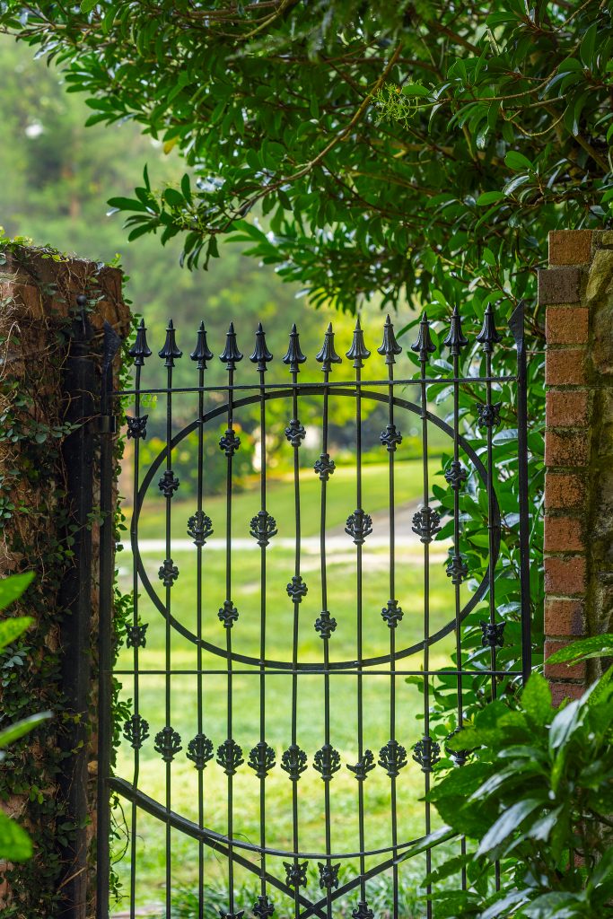 The charming wrought iron gate in the side yard is original to the home.