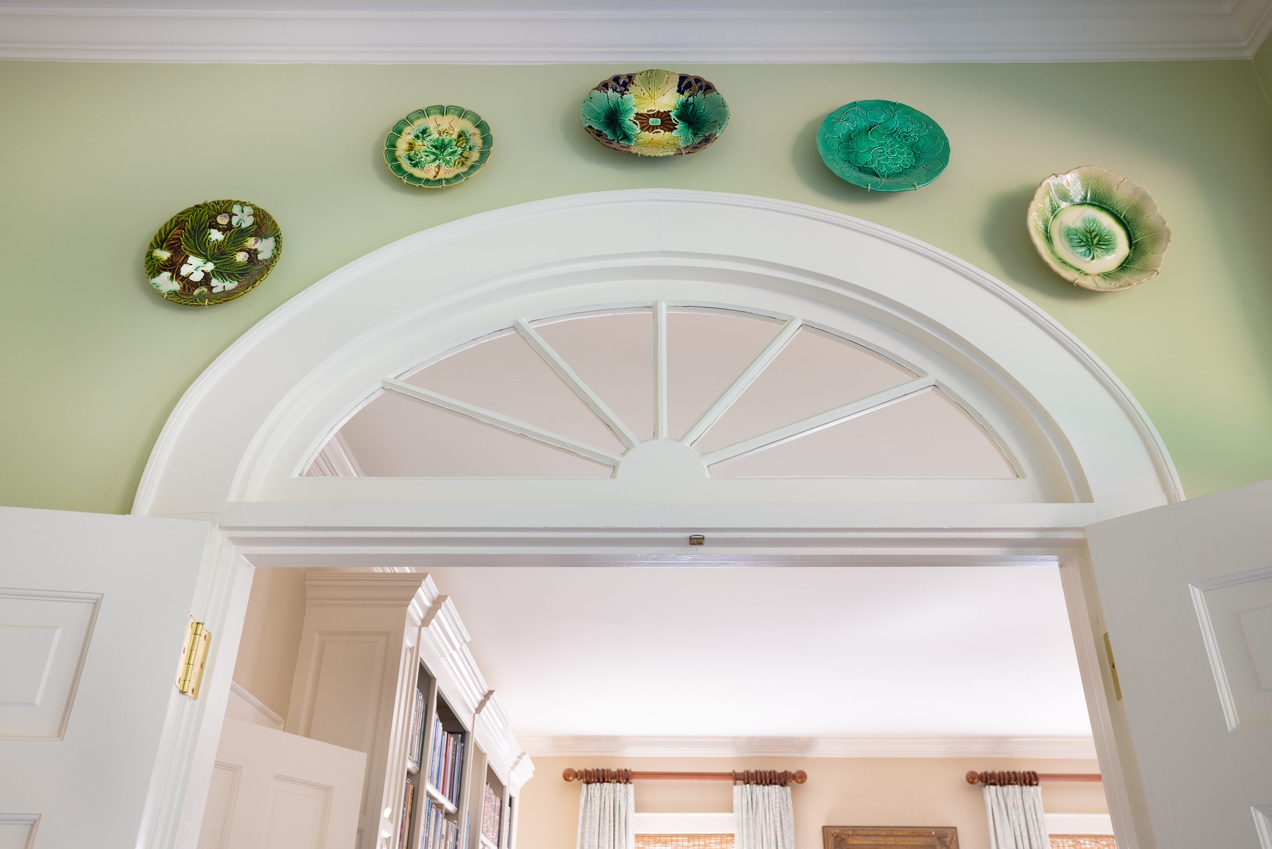 A collection of majolica plates hangs in the sunroom over attractive French doors, a detail that reflects Jill’s love of collecting antiques.