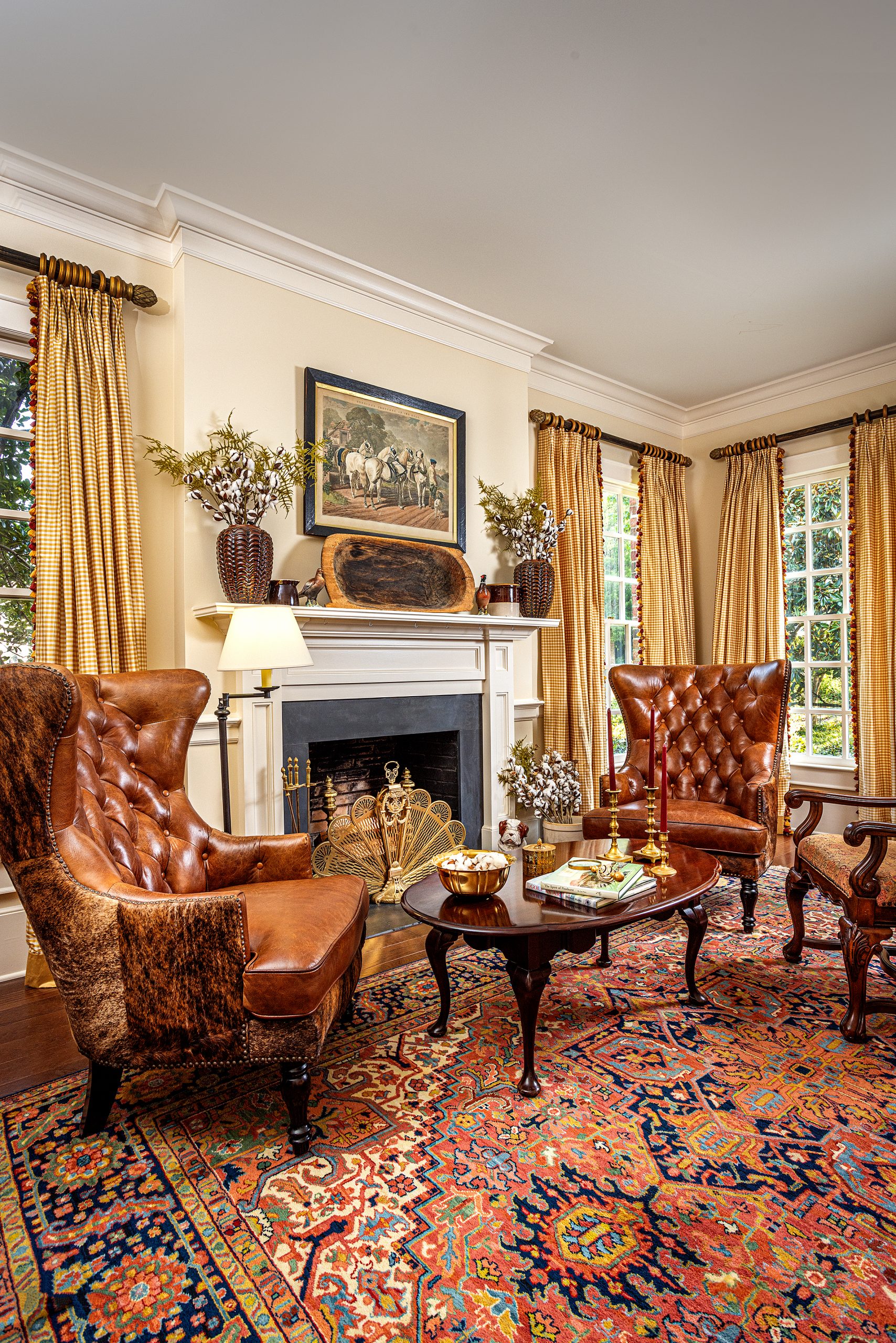 The Parhams’ living room is an homage to Jill’s love of horseback riding and traditional hunt scenes. A pair of leather and cowhide wing chairs frame the well-proportioned fireplace, adorned with cotton boll-filled pottery, quail figurines, and a carved dough bowl on the mantel. 
