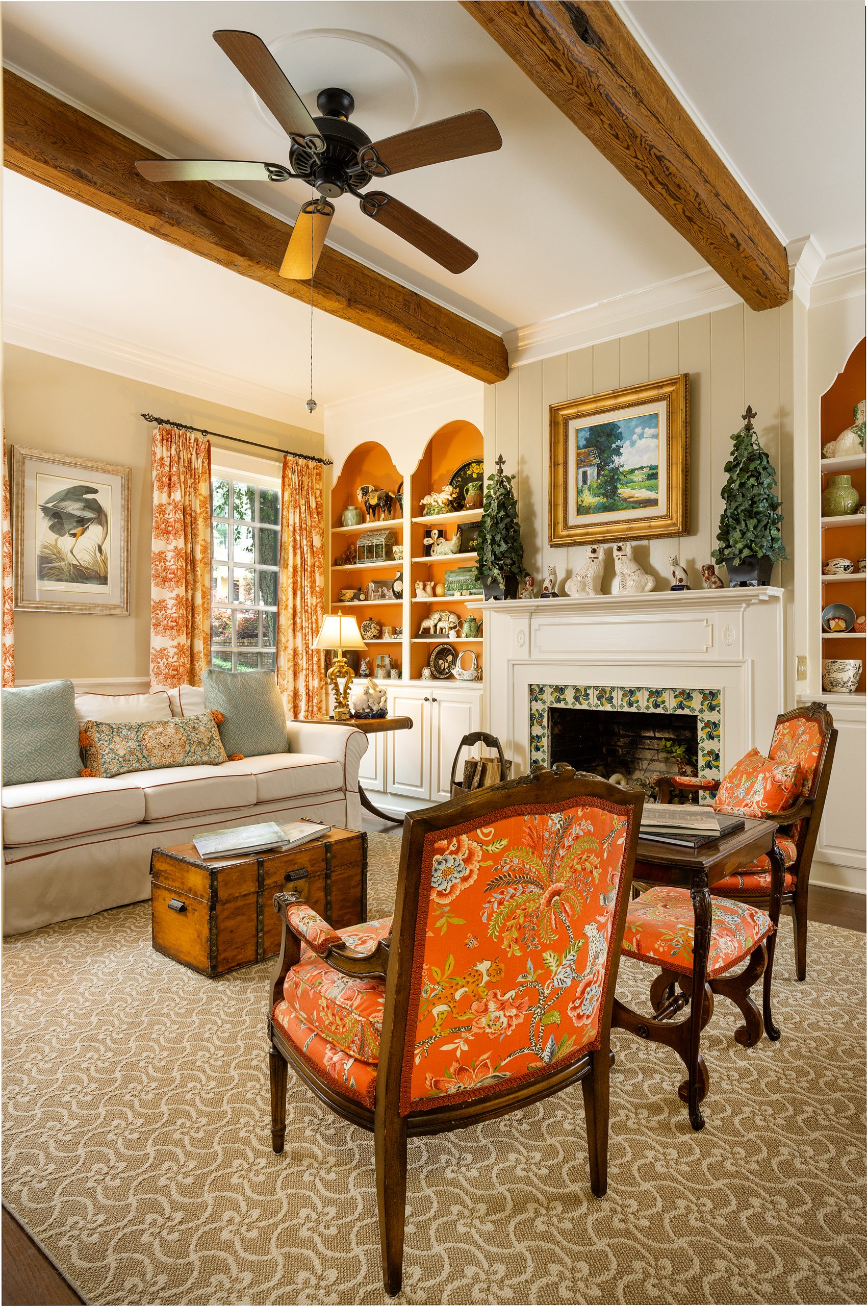 Jill’s favorite room in the house is the “little den,” accented by antique ceiling beams. Beautiful fabrics make the room cozy around a fireplace surrounded in Italian tile and flanked by bookshelves. Jill’s extensive pottery and figurine collection is highlighted by the shelves being painted a rust accent as a backdrop. An antique stagecoach trunk is used as a coffee table.