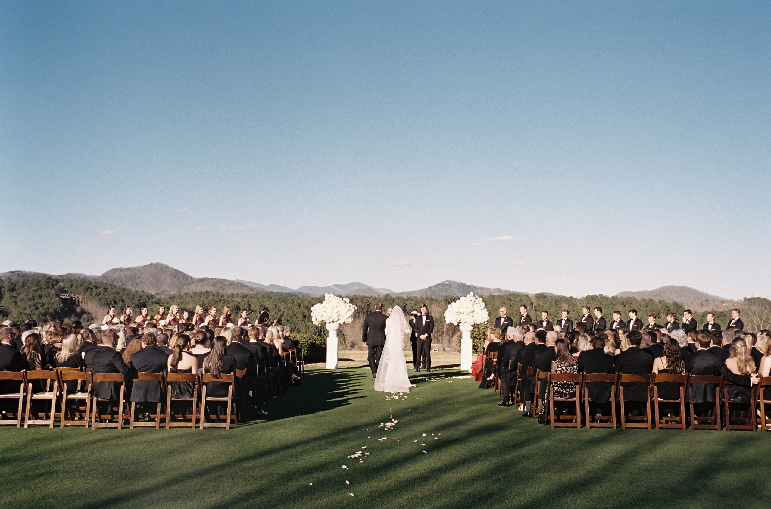  The ceremony was held on the croquet lawn at the Reserve at Lake Keowee overlooking the mountain skyline. It was officiated by Stephen Dinkins, Sutton’s uncle, who is a missionary in Kenya, and David Gentino, Sutton’s pastor at Columbia Presbyterian Church. 