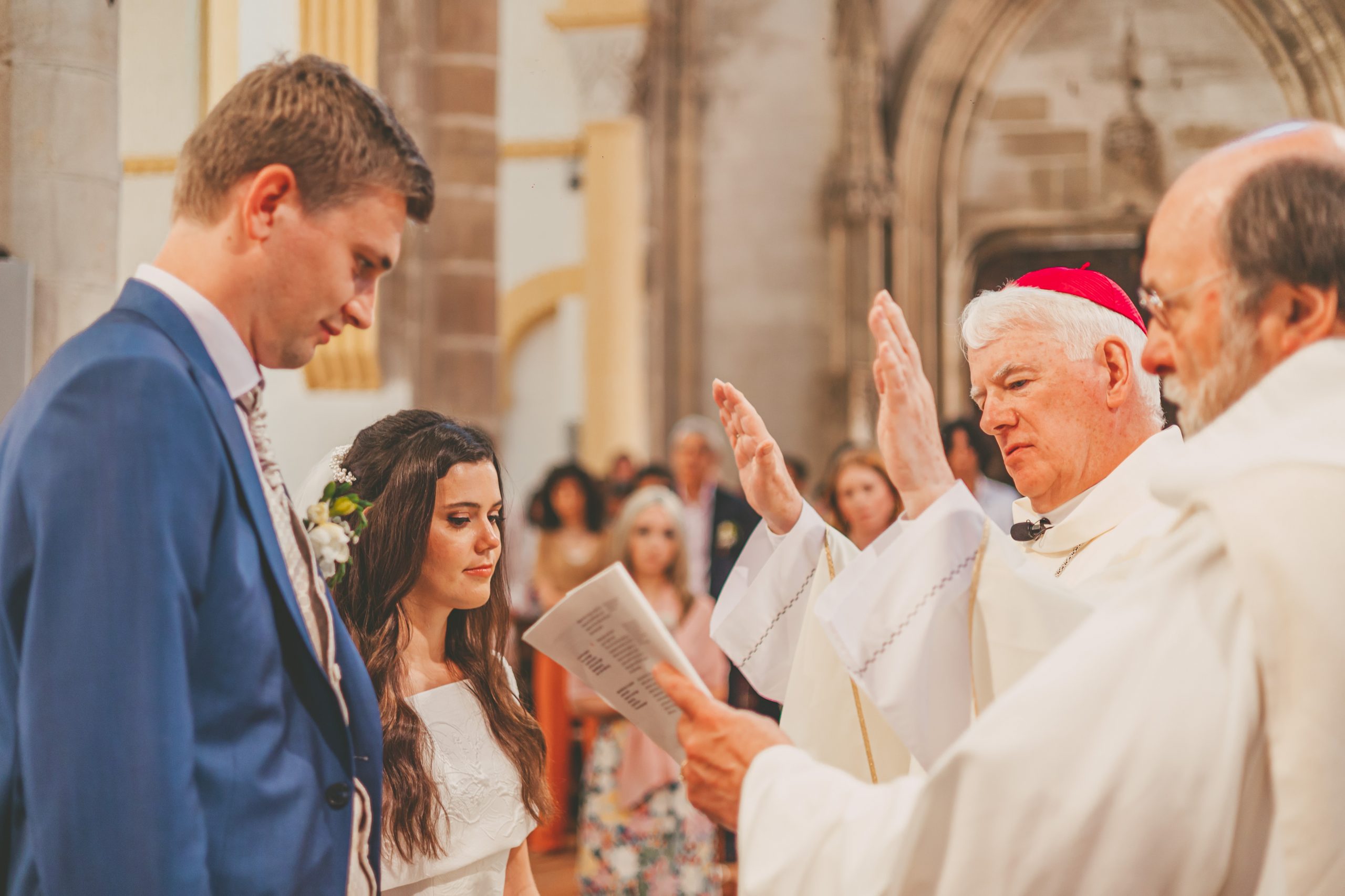 The wedding service for Théo Lunte and Frances Sadler is performed by Archbishop and Apostolic Nunciature to the European Union Noël Treanor and Michael Kuhn, deacon at L'église Saint Pierre et Saint Paul in Souvigny, France.