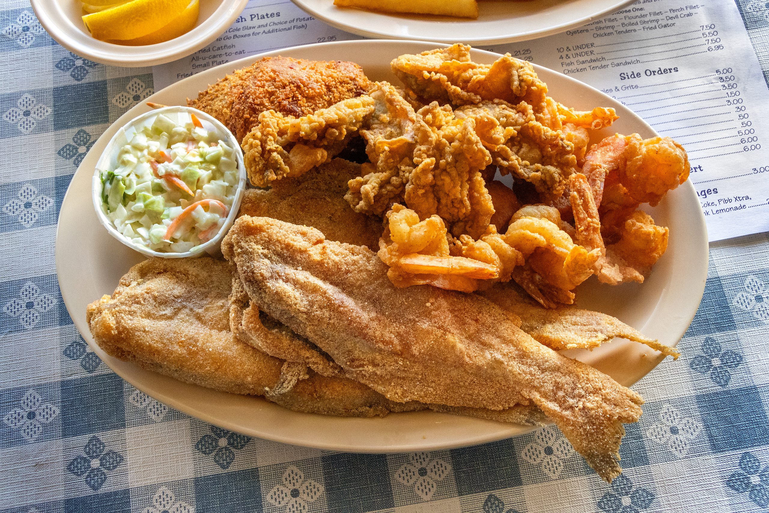 Hot tasty fish is the order of the day at fish camp restaurants. Sides consist of coleslaw, fries, and hushpuppies … all served with a smile.