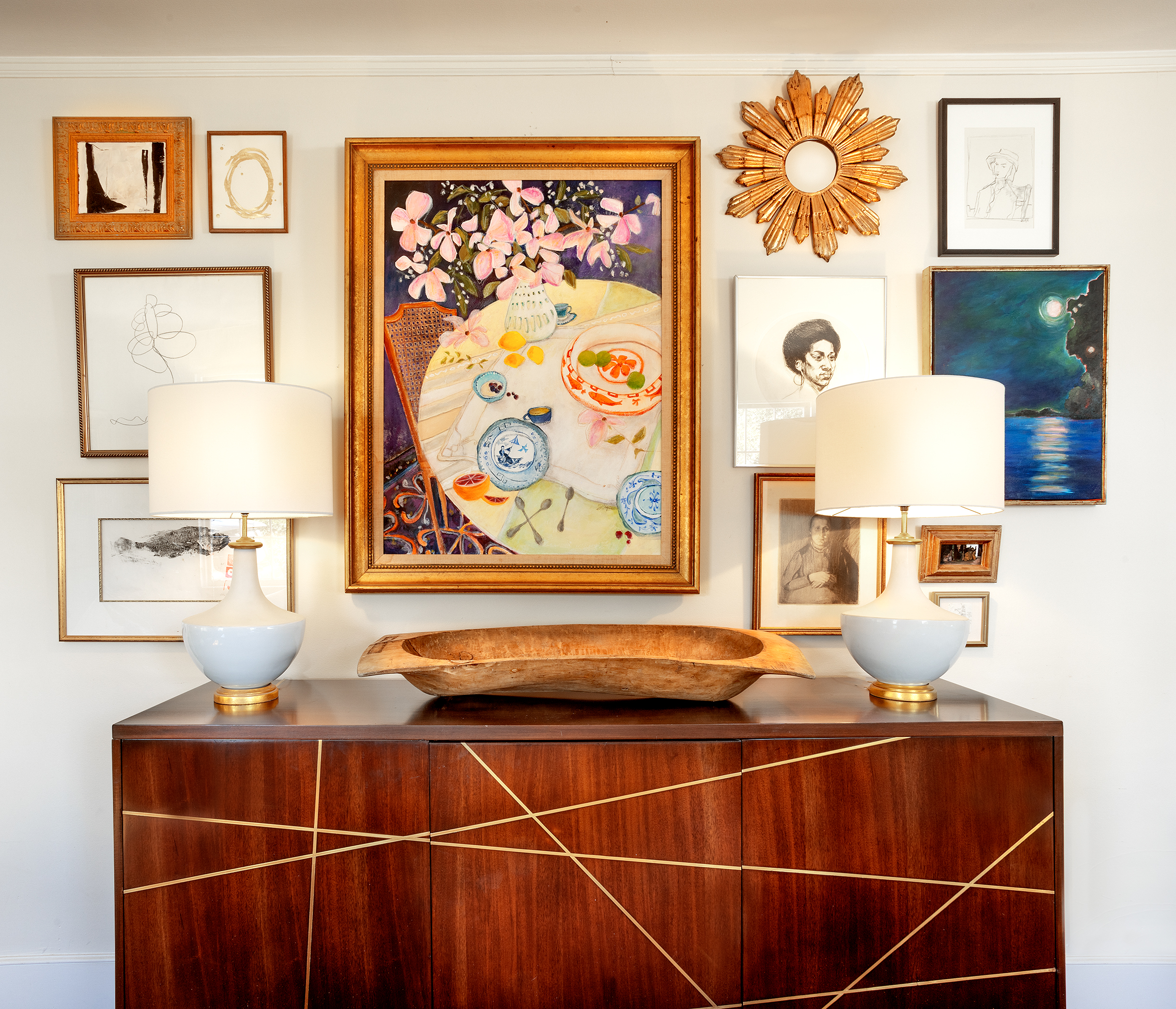 Shawn likes a mixture of realism with the abstract, along with a combination of the old and new. Her art, along with the work of many of her favorite artists, arranged above the art deco sideboard gives the room a rare eclectic ambiance.