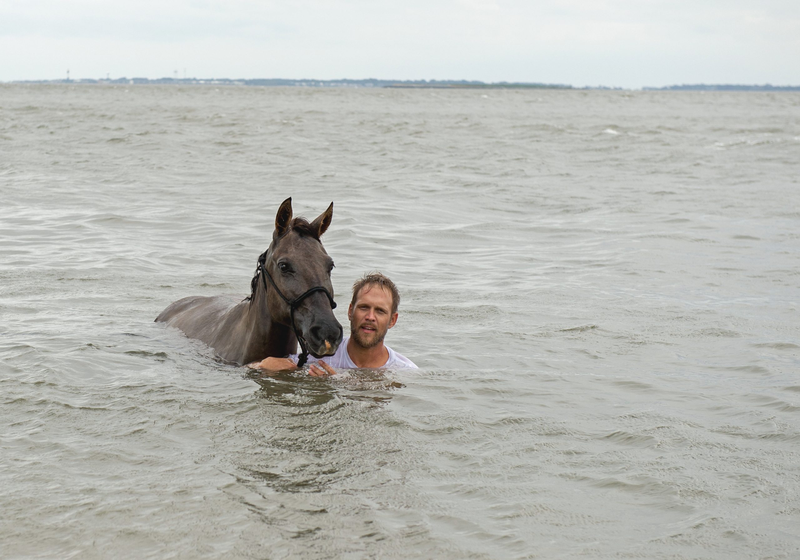 Ashley Jones swims in the ocean with his Marsh Tacky, Postel, off Daufuskie Island. 
