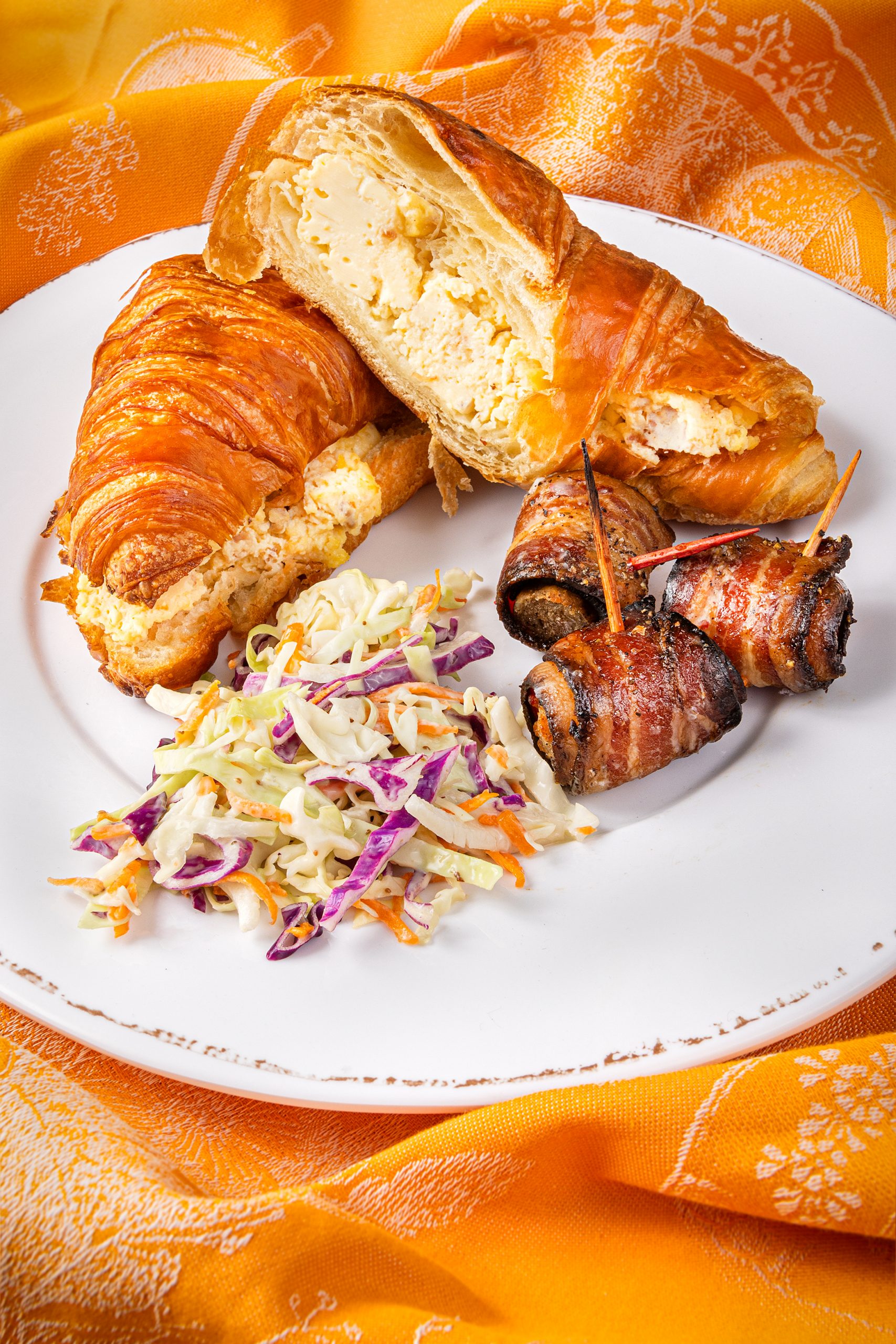 Quarterback Scramble croissant with Pigskins, recipes page 92. Vietri Melamine white dinner plate, courtesy of Kudzu Bakery & Market. Le Jacquard Francais orange tea towel, courtesy of non(e)such.